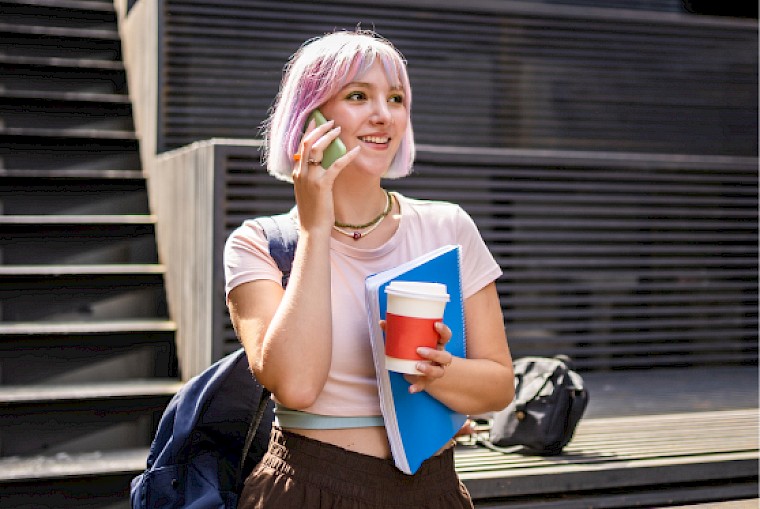 Trainees on the phone in front of the school building.