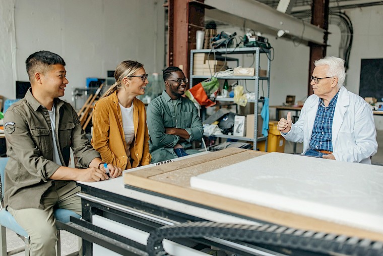 Head of further education teaches his adult students in the workshop.