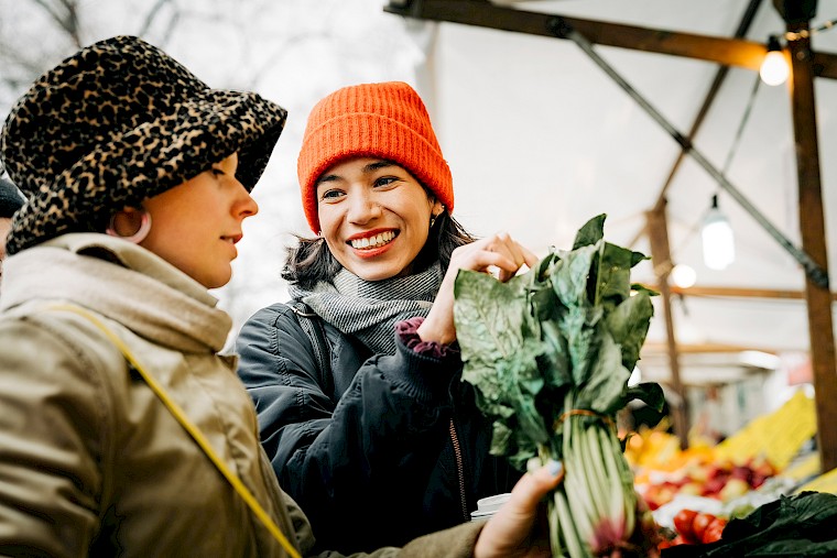 Girlfriends go shopping for vegetables together at the market.